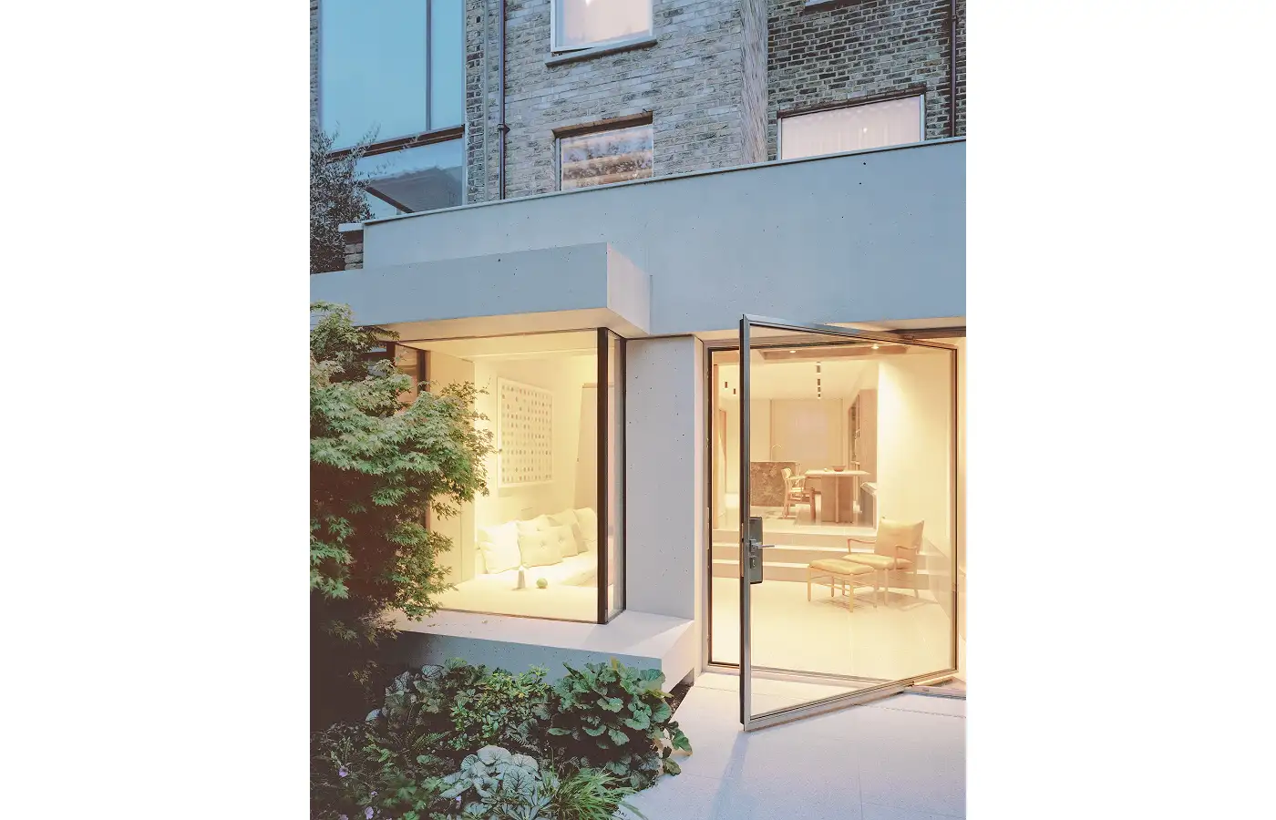 Contemporary concrete rear extension with floor-to-ceiling glazing and pivot door at Caithness Road, Hammersmith.
